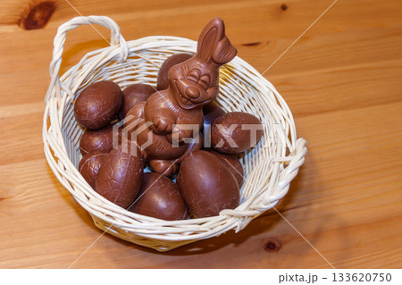 Basket with Easter eggs and Easter bunny on wooden table 133620750