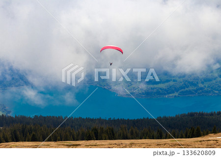Paraglider flying from Niederhorn mountain in Swiss Alps, Switzerland. Concept of active lifestyle and extreme sport adventure Paraglider flying from Niederhorn mountain in Swiss Alps, Switzerland. Concept of active lifestyle and extreme sport adventure 133620809