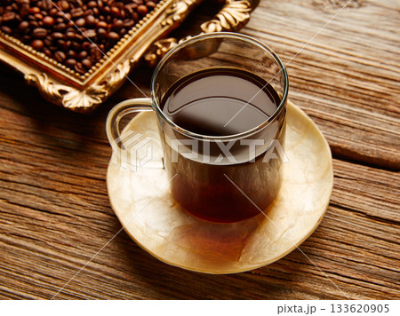 Coffee cup and beans on vintage golden tray 133620905
