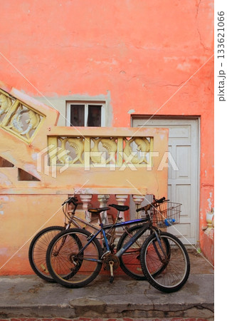 bicycles on grunge tropical Caribbean orange facade bicycles on grunge tropical Caribbean orange facade 133621066