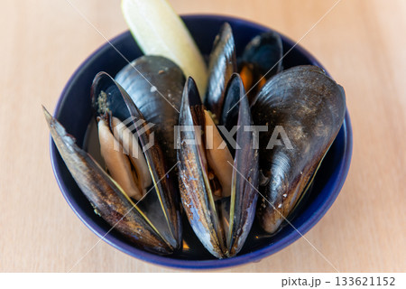 横構図のムール貝の前菜・レモン添え　ナチュラルな食卓のフード写真 133621152