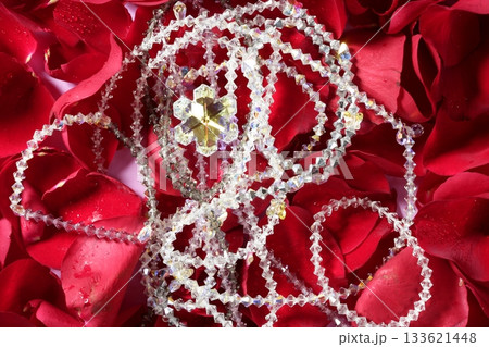Shiny jewelry over red rose petals 133621448