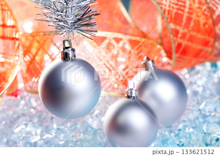 christmas silver baubles with red ribbon on ice christmas silver baubles with red ribbon on ice 133621512