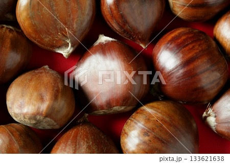 Chestnuts macro over red studio background Chestnuts macro over red studio background 133621638