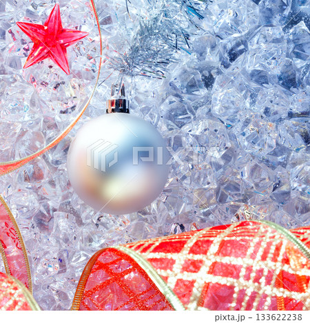christmas silver bauble and red ribbon on ice 133622238
