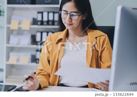 Business woman using calculator for do math finance on wooden desk in office and business working background, tax, accounting, statistics and analytic research concept. 133622694