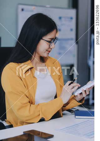 Business woman using calculator for do math finance on wooden desk in office and business working background, tax, accounting, statistics and analytic research concept. 133622696