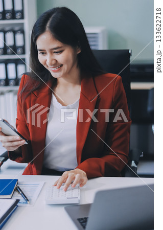 Asian business woman working on a laptop in a professional office Asian business woman working on a laptop in a professional office 133622718