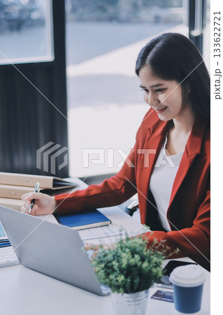 Asian business woman working on a laptop in a professional office 133622721
