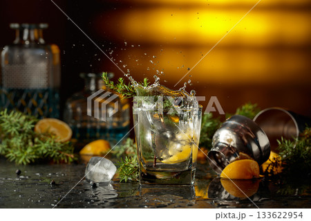 Slice of lemon fall in glass with cocktail, creating beautiful splashes. Slice of lemon fall in glass with cocktail, creating beautiful splashes. 133622954