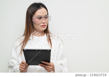 Asian Female Scientist in Protective Glasses Using Digital Tablet Computer Thinking Asian Female Scientist in Protective Glasses Using Digital Tablet Computer Thinking 133623719