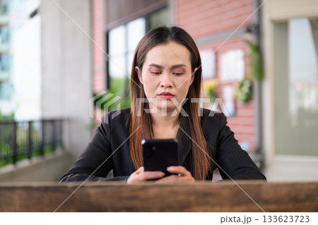 Thai Business Woman Outdoors in Professional Attire Using Phone Thai Business Woman Outdoors in Professional Attire Using Phone 133623723