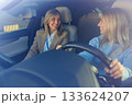 Driving Lesson with Smiling Learner and Instructor Inside Vehicle 133624207