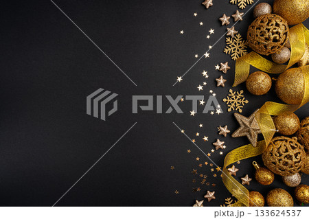 Golden Christmas Ornaments and Ribbon on Black Background Golden Christmas Ornaments and Ribbon on Black Background 133624537