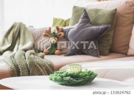 Cozy Living Room with Crocheted Reindeer Toy on Sofa and Christmas Holiday Candle Decor on Table Cozy Living Room with Crocheted Reindeer Toy on Sofa and Christmas Holiday Candle Decor on Table 133624762