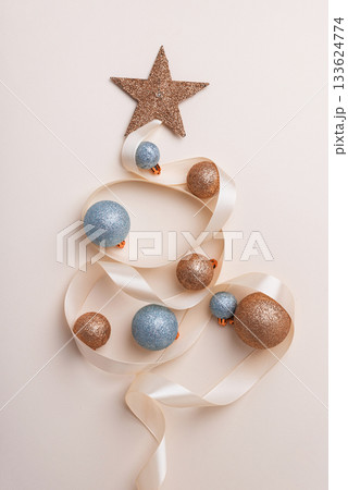 Minimalist Christmas Tree Made of Ribbon and Ornaments on Light Background Minimalist Christmas Tree Made of Ribbon and Ornaments on Light Background 133624774