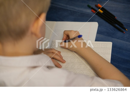 Child tracing patterns in notebook learning new skills 133626864