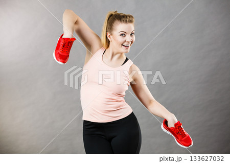 Happy woman presenting sportswear trainers shoes 133627032