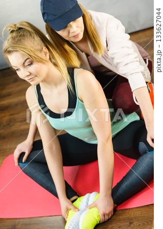 Woman in sportswear doing workout with trainer 133627044