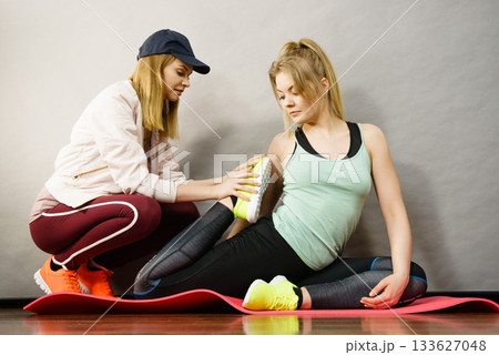 Woman in sportswear doing workout with trainer 133627048