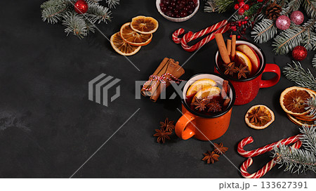 Strong alcoholic or non-alcoholic cocktail in iron mugs, mulled wine with spices, star anise, cranberries, orange, apple and cinnamon, warming winter drink in the cold season, Christmas festive grog, 133627391