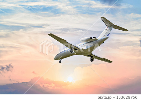 Private business plane flying under blue sky with white clouds 133628750