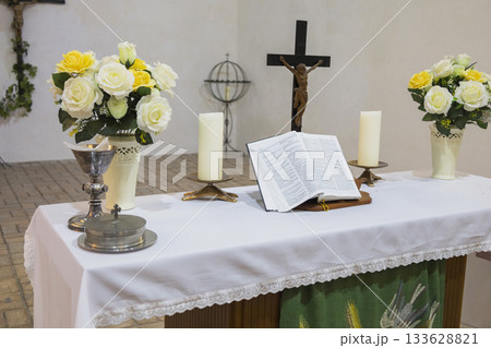 Sacred morning ceremony, Church setup with symbols of faith, Preparation of sacred space for morning worship, Serene chapel arrangement with candles and religious icons 133628821