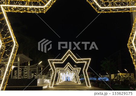 Illuminated star-shaped arches in night garden 133629175