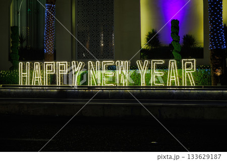 Illuminated happy New Year sign with lights 133629187