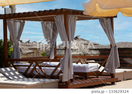 White beach canopy. Luxury beach tents with white curtains at the resort. Summer vacation concept. Beach bungalows in Sochi, Mandarin Beach, Adler, Russia 133629324