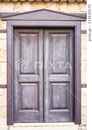 Rustic wooden door with stone wall background in sunlit outdoor setting Rustic wooden door with stone wall background in sunlit outdoor setting 133630570