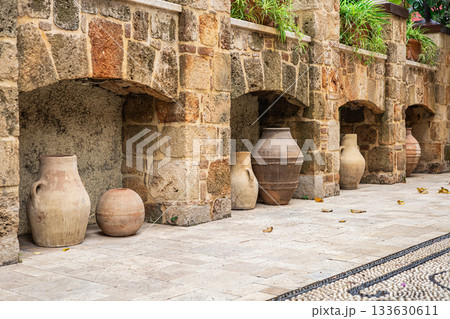 Rustic stone wall with clay pots in a mediterranean courtyard Rustic stone wall with clay pots in a mediterranean courtyard 133630611