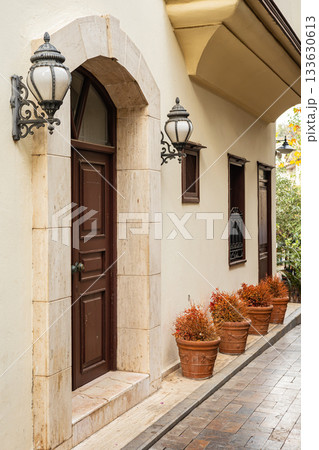Charming mediterranean alley with wooden door and decorative lanterns Charming mediterranean alley with wooden door and decorative lanterns 133630613