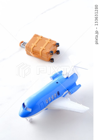 飛行機とスーツケース - 離陸を待つ飛行機とスーツケース（キャリーケース）で旅行に出発するイメージ 133631280