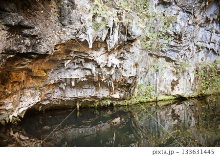 Rocky cliffside reflected in water Rocky cliffside reflected in water 133631445