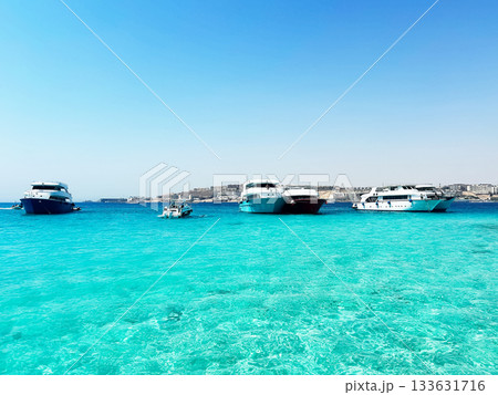 Yachts anchored in clear turquoise water 133631716