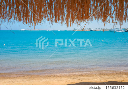 Straw umbrella overlooking the turquoise Red Sea in Egypt Straw umbrella overlooking the turquoise Red Sea in Egypt 133632152