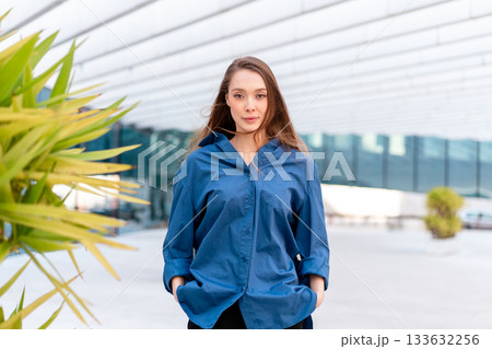 Confident businesswoman in blue shirt standing Confident businesswoman in blue shirt standing 133632256