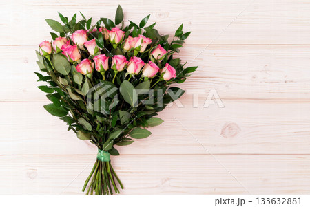 Pink rose bouquet greenery natural light romantic floral arrangement on wooden board, gentle bright mood, high resolution natural look 133632881