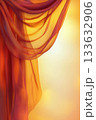 Soft, flowing fabric in warm orange and yellow hues creates serene atmosphere, evoking sense of calm and tranquility 133632906