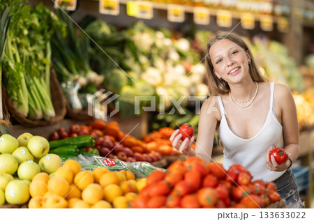 Young woman choosing tomatoes at vegetable shop 133633022