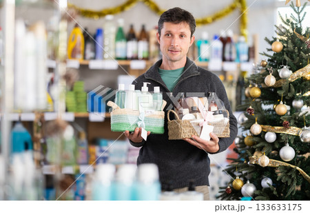 Adult man buyer chooses cosmetics gift set for christmas 133633175