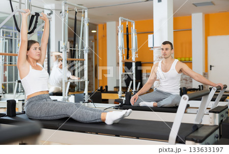 Young woman performing exercises on pilates Cadillac table 133633197