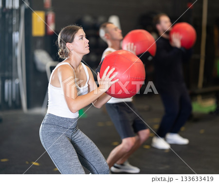Girl performing intense cross workout with medicine ball 133633419