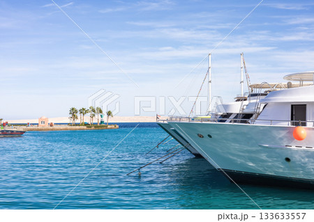 Luxurious yachts moored in a tranquil marina with clear blue waters Luxurious yachts moored in a tranquil marina with clear blue waters 133633557