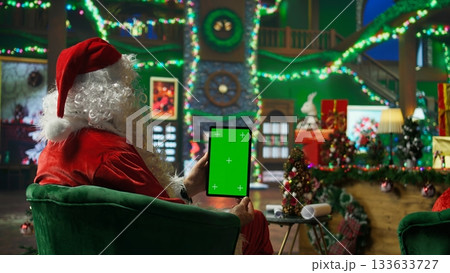 Santa Claus responding to kids requesting gifts, typing on isolated screen tablet. Person impersonating Santa Claus asking children what they want for Christmas using mockup device, camera A 133633727