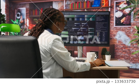 Teleworking computer scientist at home using PC to develop artificial intelligence self learning algorithms. African american woman working with AI machine learning software on PC, camera B Teleworking computer scientist at home using PC to develop artificial intelligence self learning algorithms. African american woman working with AI machine learning software on PC, camera B 133633730