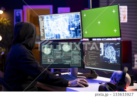 Rogue programmer uses AI on isolated screen PC to develop malware undetectable by antivirus. Hooded hacker uses chroma key computer and artificial intelligence to build script doing data mining 133633927