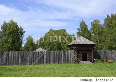 Wooden log wall and an entrance tower, restoration of a medieval fortress in Siberia, Russia Wooden log wall and an entrance tower, restoration of a medieval fortress in Siberia, Russia 133634212
