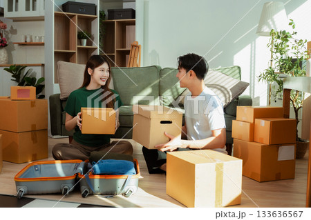 young couple helps put things in boxes and prepares to move to a new house. 133636567